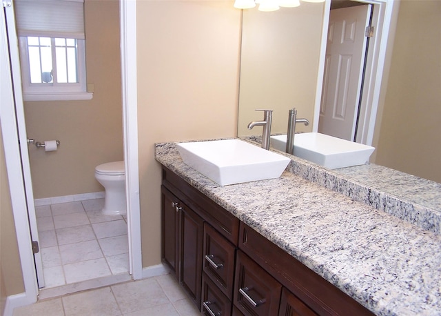 bathroom featuring toilet, baseboards, vanity, and tile patterned flooring