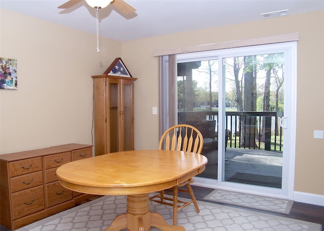 dining room with light wood-style floors, visible vents, baseboards, and a ceiling fan