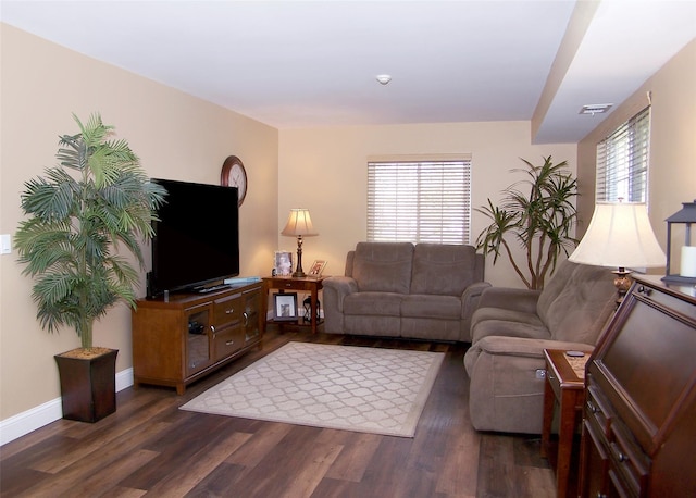 living room featuring baseboards, dark wood-type flooring, and visible vents