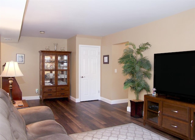 living room featuring baseboards and dark wood finished floors