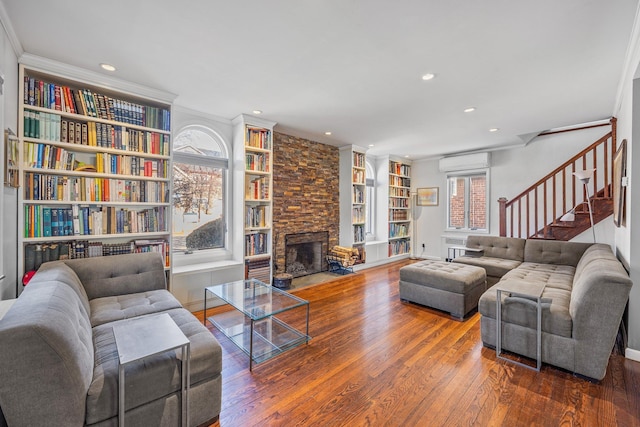 8702 Chevy Chase St, Jamaica Estates, NY 11432 - living area featuring a wall mounted AC, wood-type flooring, a stone fireplace, stairs, and recessed lighting