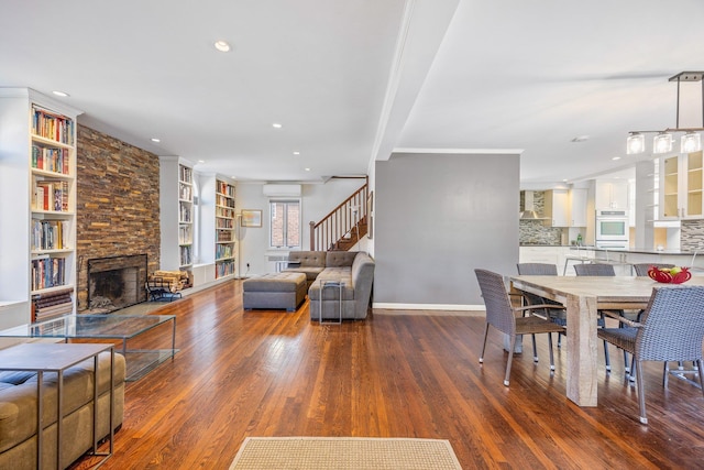 8702 Chevy Chase St, Jamaica Estates, NY 11432 - dining area featuring a fireplace, wood finished floors, stairs, built in features, and a wall mounted air conditioner