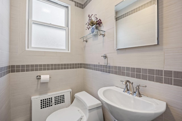 8702 Chevy Chase St, Jamaica Estates, NY 11432 - bathroom with a sink, tile walls, toilet, backsplash, and radiator heating unit