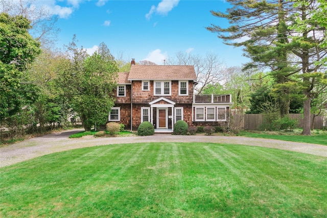 7 N Howells Point Rd, Bellport Village, NY 11713 - view of front of house featuring curved driveway, a chimney, a balcony, and a shingled roof