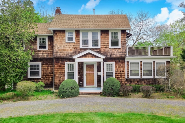 7 N Howells Point Rd, Bellport Village, NY 11713 - view of front facade featuring a balcony, a chimney, and a shingled roof