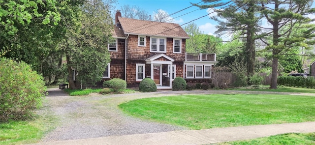 7 N Howells Point Rd, Bellport Village, NY 11713 - view of front of house with a chimney, a balcony, gravel driveway, and roof with shingles