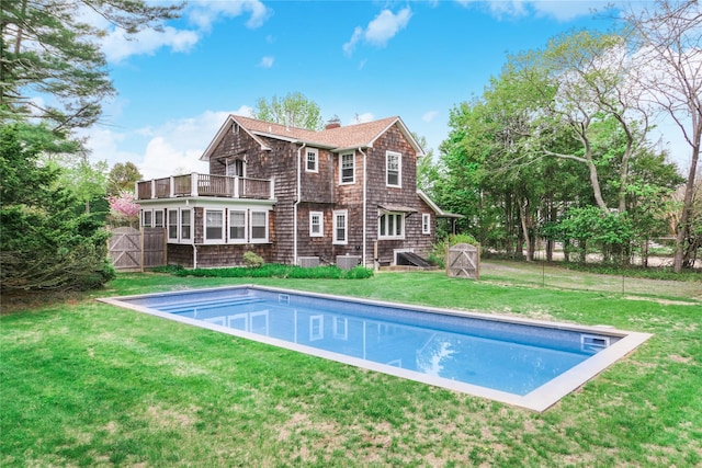 7 N Howells Point Rd, Bellport Village, NY 11713 - back of house featuring a chimney, an outdoor pool, a balcony, and roof with shingles