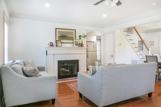 7 N Howells Point Rd, Bellport Village, NY 11713 - living room featuring a ceiling fan, stairs, ornamental molding, dark wood-style flooring, and a fireplace