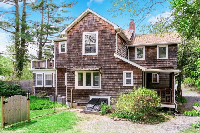 7 N Howells Point Rd, Bellport Village, NY 11713 - back of house with a chimney, a shingled roof, central AC, and a balcony