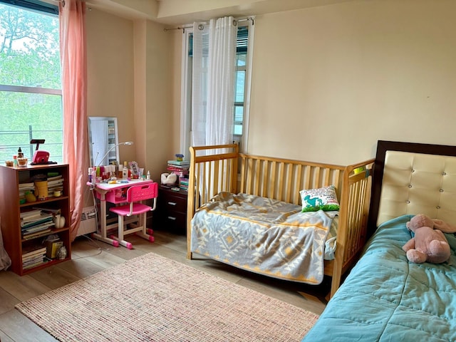 bedroom featuring a baseboard heating unit and wood finished floors