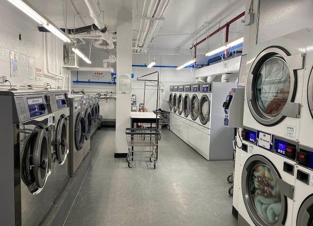 common laundry area featuring washer and dryer, a garage, and stacked washer / drying machine