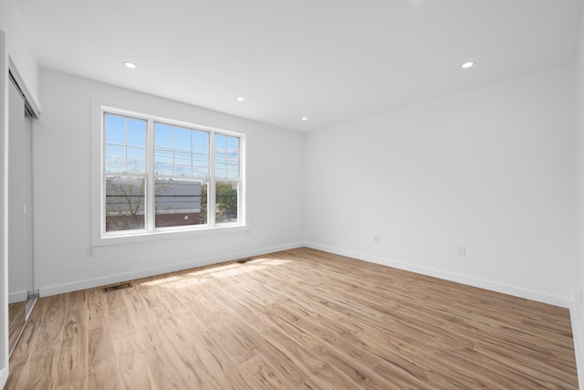 interior space with light wood-style floors, visible vents, baseboards, and recessed lighting