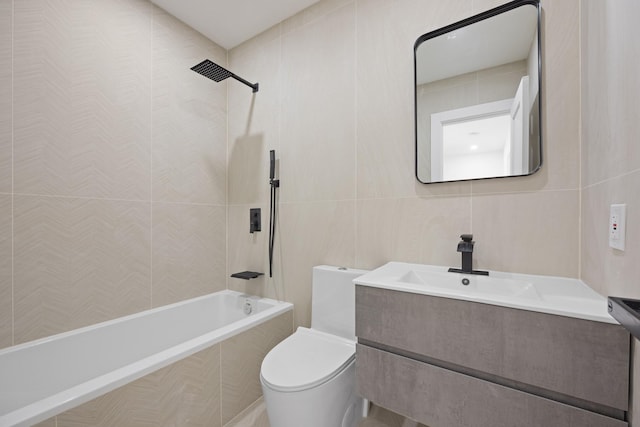 bathroom with toilet, tile walls, vanity, and tiled shower / bath