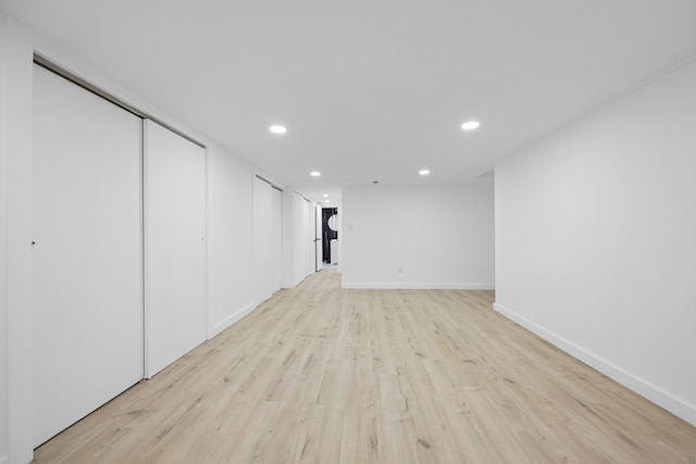 finished basement featuring light wood finished floors, baseboards, and recessed lighting