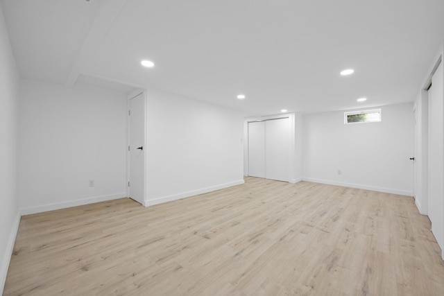 below grade area with light wood-type flooring, baseboards, and recessed lighting