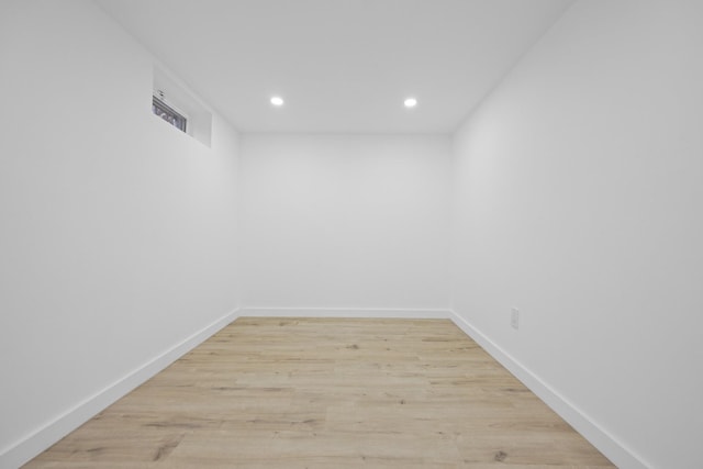 empty room featuring baseboards, light wood-type flooring, and recessed lighting