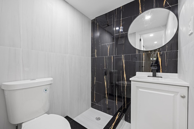 bathroom featuring vanity, tile walls, toilet, and a tile shower