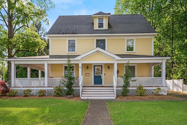 farmhouse-style home featuring a porch, a shingled roof, and a front lawn