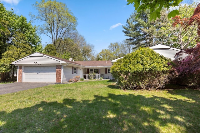 ranch-style house featuring an attached garage, a front yard, driveway, and brick siding
