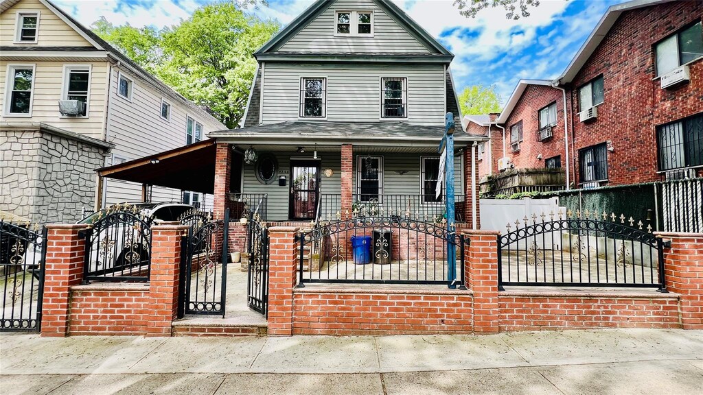 4308 68th St Unit 2Family, Woodside, NY 11377 - view of front of house featuring a porch, a fenced front yard, and a gate