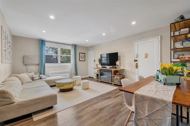 living room with radiator heating unit, wood finished floors, and recessed lighting