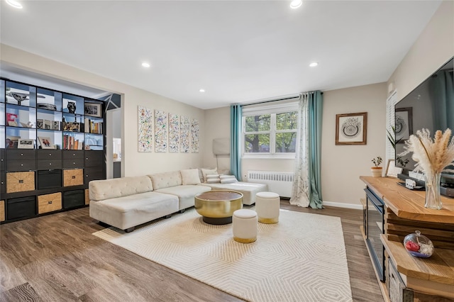 living area featuring baseboards, radiator, recessed lighting, and wood finished floors