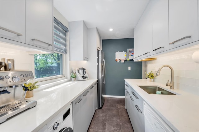kitchen with freestanding refrigerator, dishwasher, a sink, light countertops, and tasteful backsplash