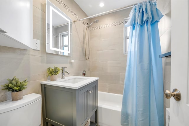 full bathroom featuring tile walls, toilet, shower / tub combo with curtain, and vanity