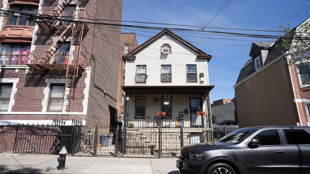 2771 Marion Ave, Bronx, NY 10458 - view of front of property featuring a fenced front yard, a porch, and brick siding