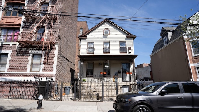 2771 Marion Ave, Bronx, NY 10458 - view of front of property featuring a fenced front yard, a porch, and brick siding