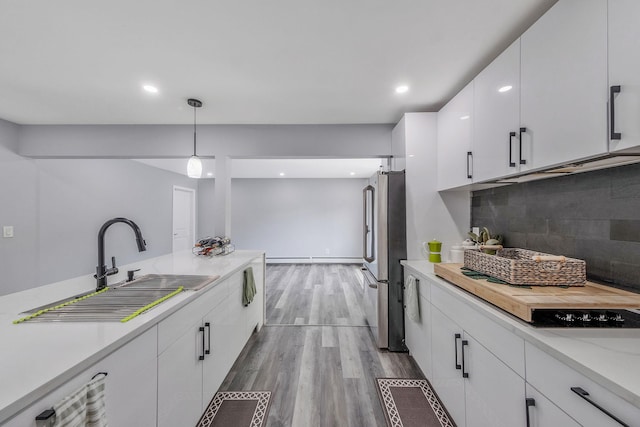 73 S Evergreen Dr, Selden, NY 11784 - kitchen featuring wood finished floors, a sink, freestanding refrigerator, white cabinets, and light countertops