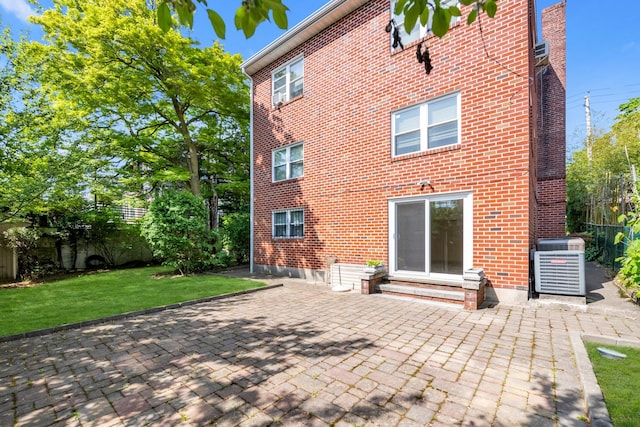 2330 Kingsland Ave, Bronx, NY 10469 - back of house featuring brick siding, central AC unit, a patio area, and entry steps