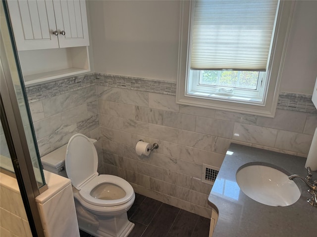 2330 Kingsland Ave, Bronx, NY 10469 - bathroom with tile walls, toilet, a wainscoted wall, and vanity