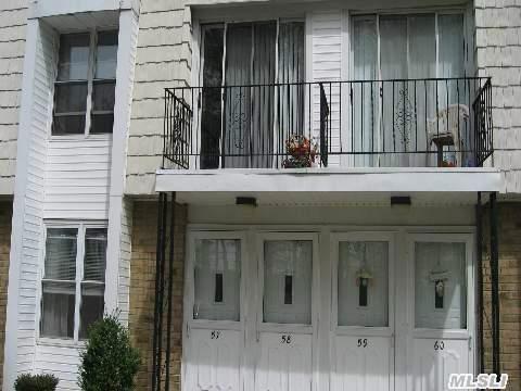 exterior space featuring a balcony and brick siding