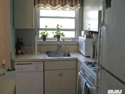 kitchen featuring a sink, white cabinetry, white appliances, and light countertops