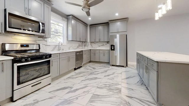 kitchen with gray cabinetry, marble finish floor, ceiling fan, a sink, and stainless steel appliances