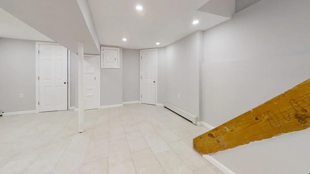 finished basement with recessed lighting, baseboards, and a baseboard heating unit
