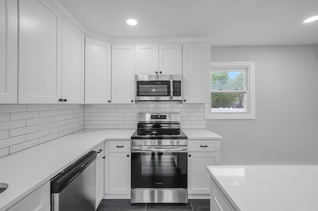 kitchen featuring stainless steel appliances, light countertops, decorative backsplash, white cabinets, and recessed lighting