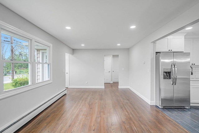 unfurnished living room with baseboard heating, dark wood-type flooring, baseboards, and recessed lighting