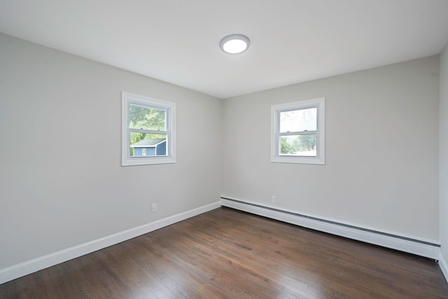 unfurnished room with baseboard heating, healthy amount of natural light, baseboards, and wood finished floors