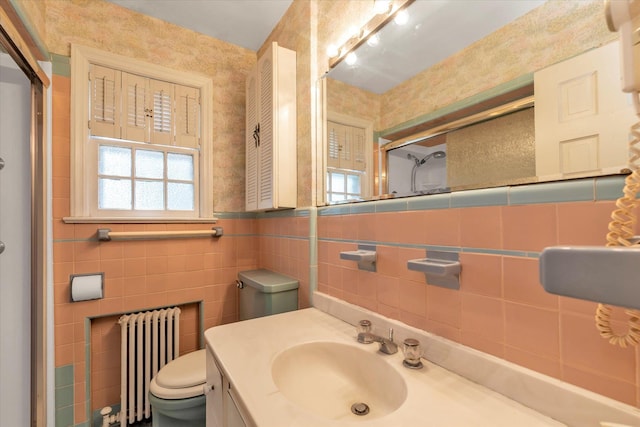 bathroom with radiator heating unit, plenty of natural light, a stall shower, tile walls, and toilet