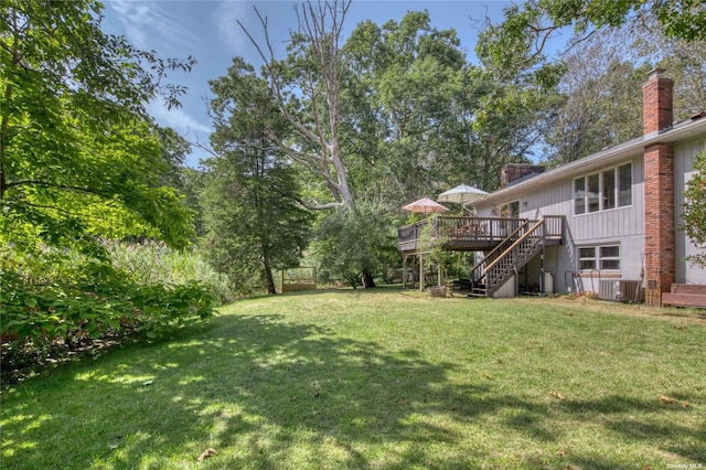 view of grassy yard featuring stairway, a wooden deck, and cooling unit