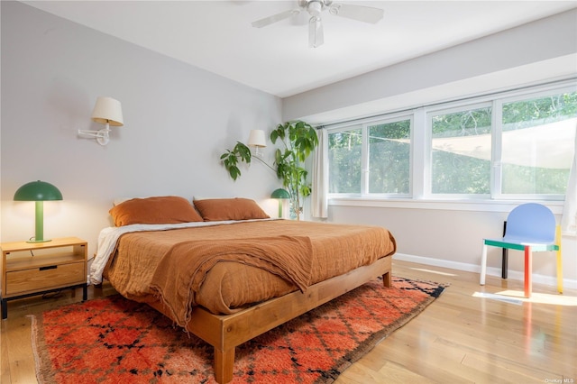 bedroom featuring wood finished floors, baseboards, and ceiling fan