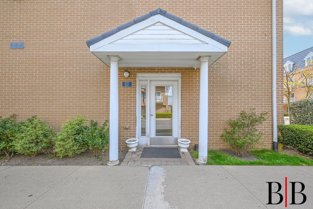 view of exterior entry featuring brick siding
