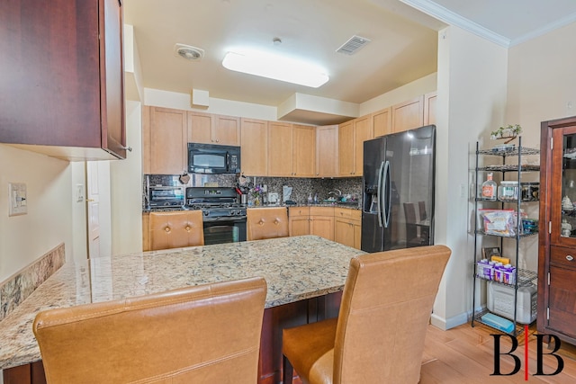 kitchen featuring visible vents, a peninsula, decorative backsplash, black appliances, and light wood-type flooring