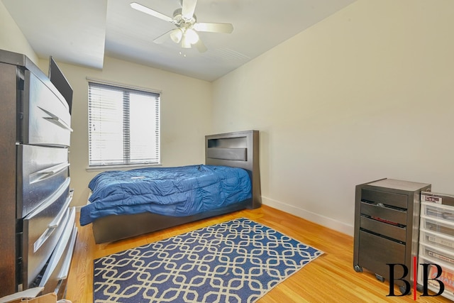 bedroom with baseboards, a ceiling fan, and wood finished floors