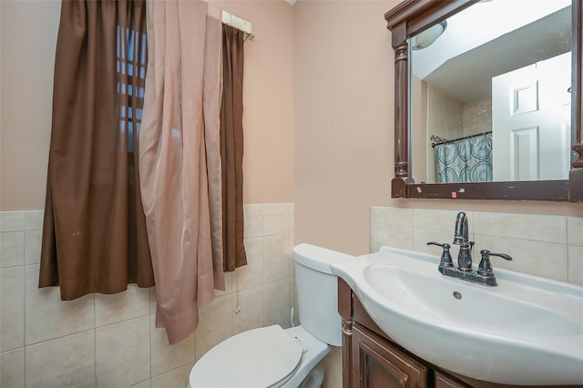 full bathroom with toilet, tile walls, vanity, and wainscoting
