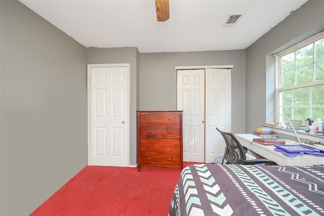 carpeted bedroom with ceiling fan, a closet, and visible vents
