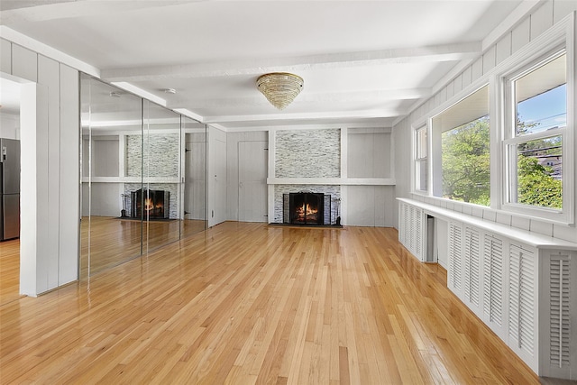 202 W Main St, Mount Kisco, NY 10549 - unfurnished living room with a lit fireplace, beamed ceiling, and light wood finished floors