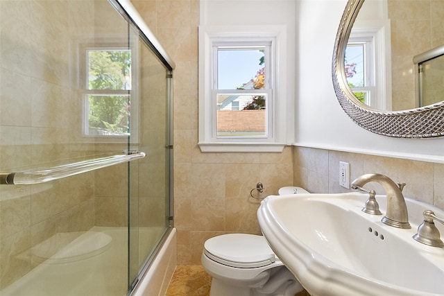 202 W Main St, Mount Kisco, NY 10549 - full bathroom with a sink, tile walls, toilet, plenty of natural light, and shower / bath combination with glass door